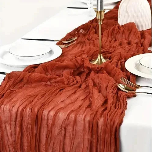 Chemin de table terracotta accordé à une table dressée aux chandeliers dorés