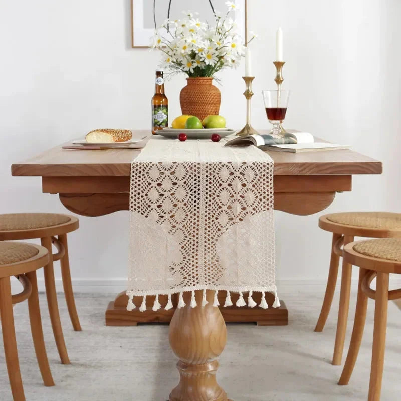 Table dressée avec serviettes pliées et chemin de table en macramé crème