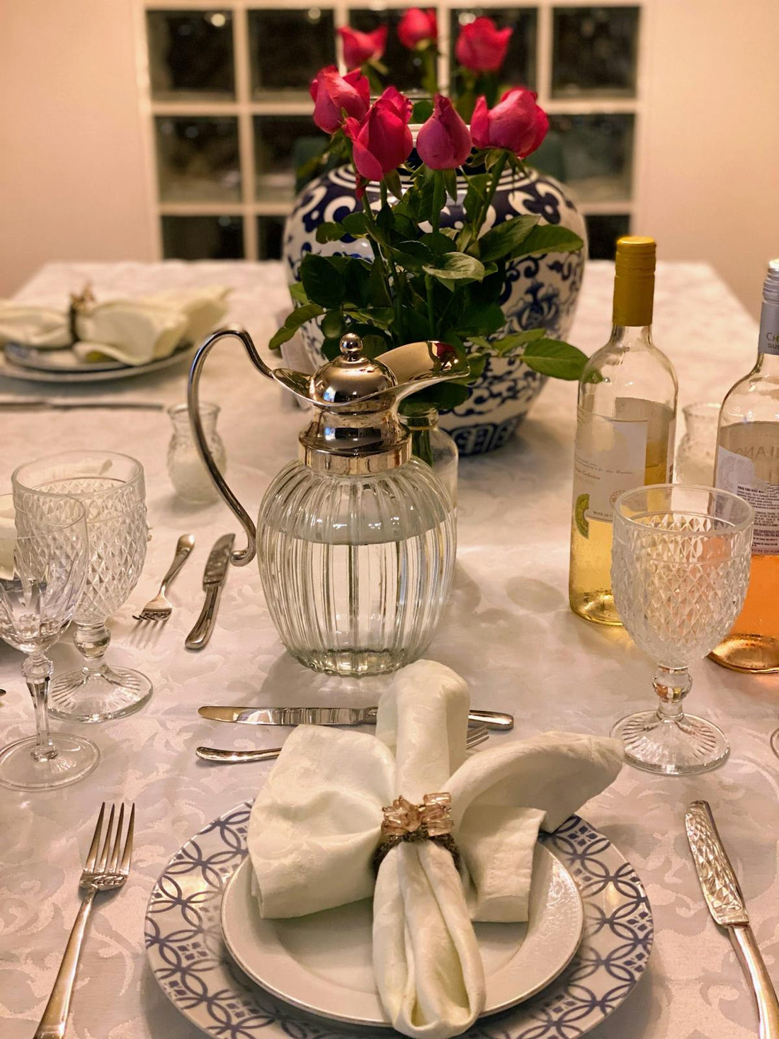 Belle table dressée avec roses, assiettes et verres