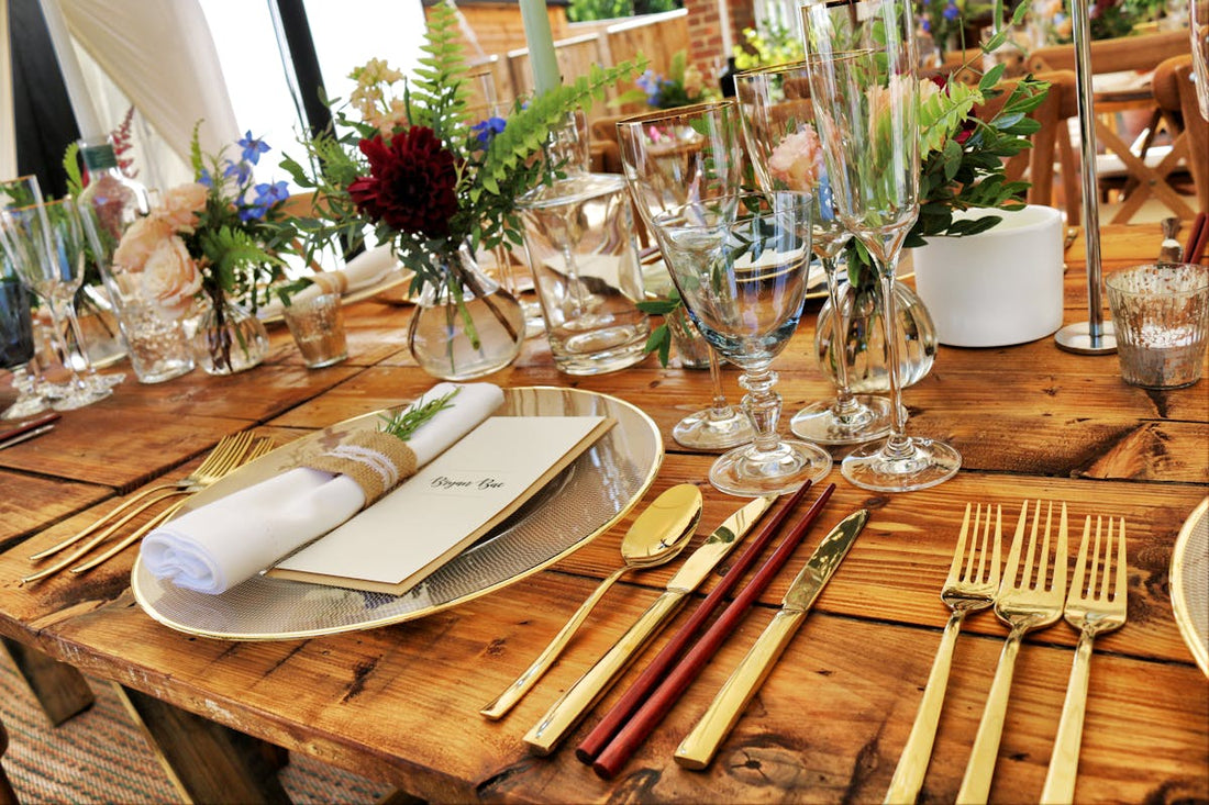 Table en bois dressée avec soin, couverts et fleurs