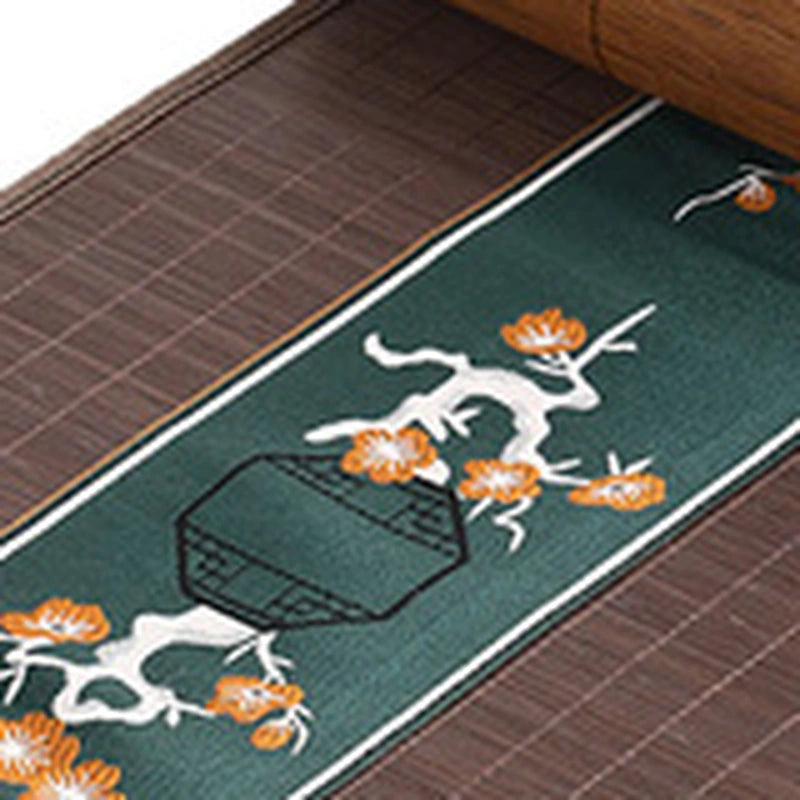Gros plan de la broderie de fleurs orange sur bandeau vert sapin