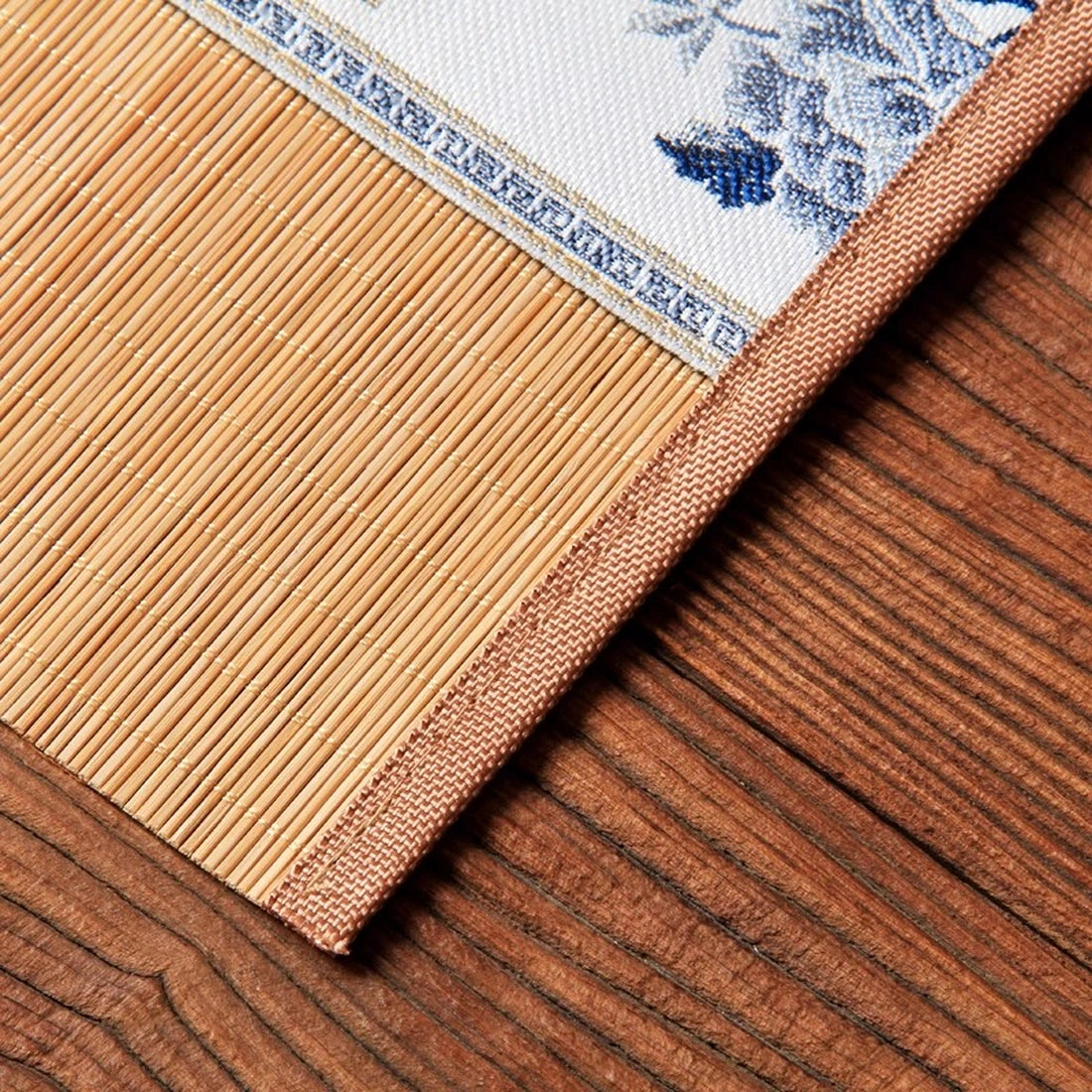 Détail du coin relevé, bandeau écru à fleurs bleues sur lattes de bambou naturel
