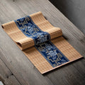 Chemin de table en bambou naturel à bandeau bleu porcelaine, posé sur une table en bois