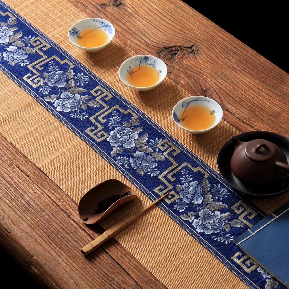 Chemin de table en bambou naturel dressé avec une théière et trois coupes de thé