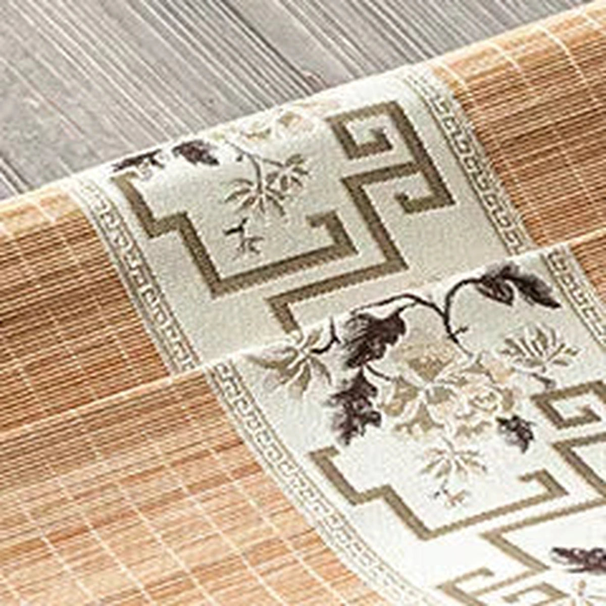 Gros plan de la broderie de fleurs taupe sur fond écru