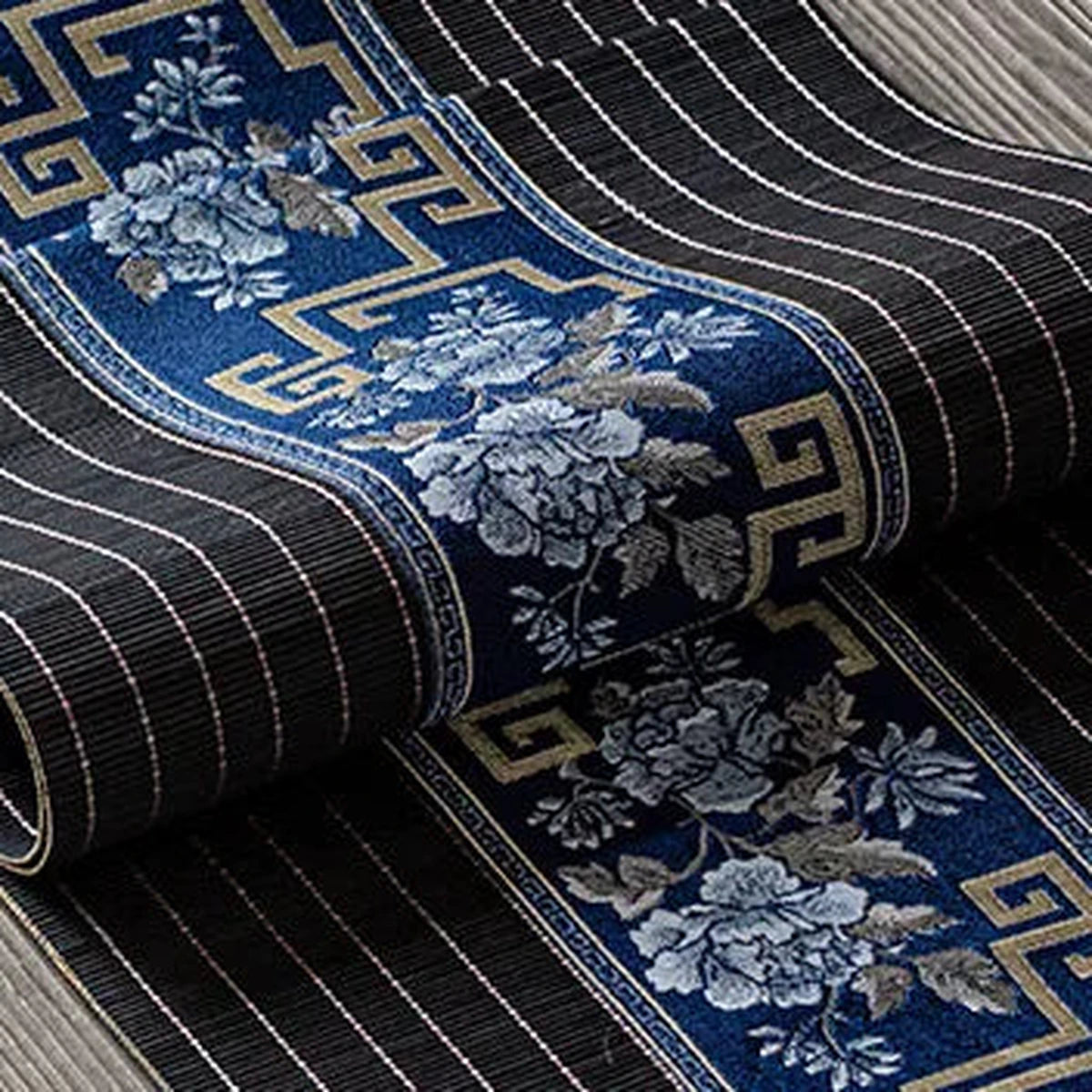 Détail du tissage de bambou noir rayé et du bandeau brodé bleu