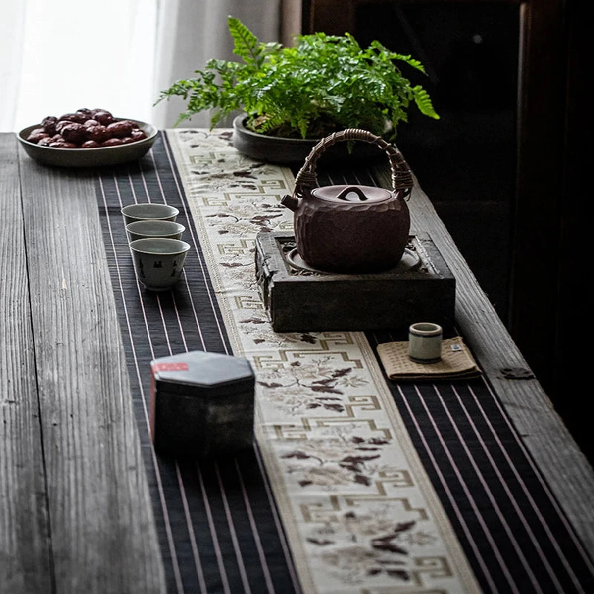 Chemin de table en bambou noir dressé avec théière et coupelles