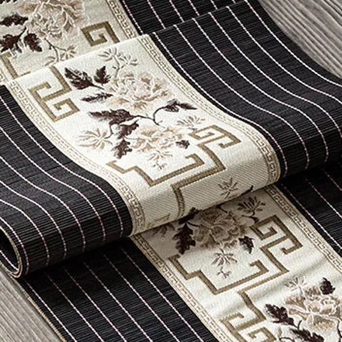 Détail du tissage de bambou noir rayé et du bandeau brodé taupe