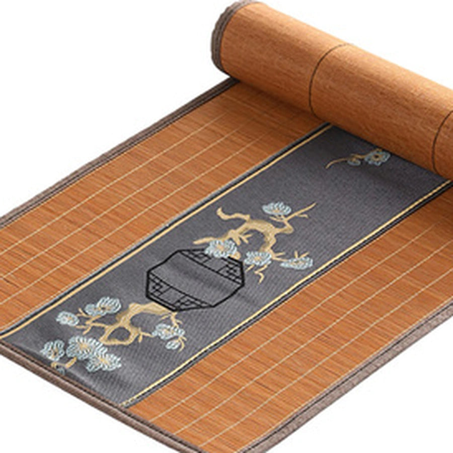 Détail du tissage de bambou terracotta et du bandeau brodé gris