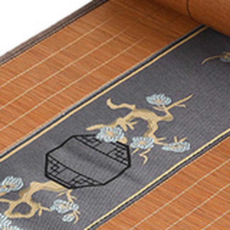 Gros plan de la broderie de branche de pin dorée sur bandeau gris
