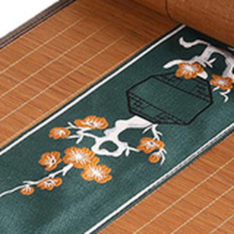 Gros plan de la broderie de fleurs orange sur bandeau vert sapin