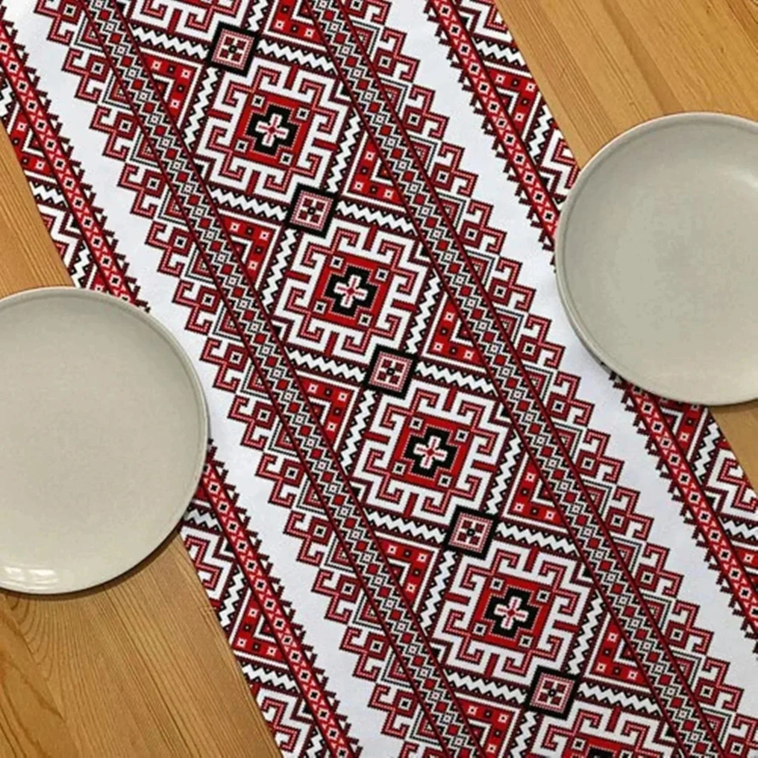 Chemin de table brodé folk rouge et noir sur une table en bois