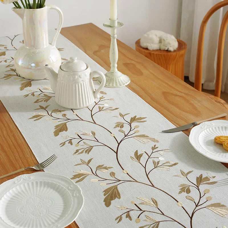 Chemin de table brodé feuillage avec théière et chandelles