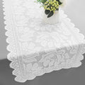 Petit chemin de table en dentelle blanche sur une table en bois