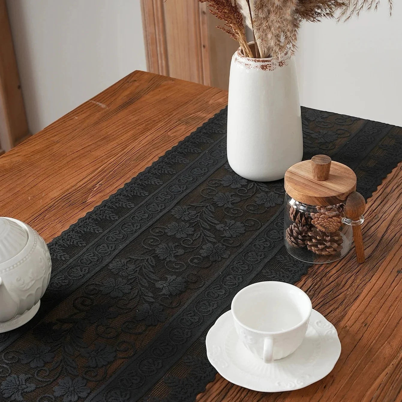 Chemin de table dentelle noire avec vase et tasses de café
