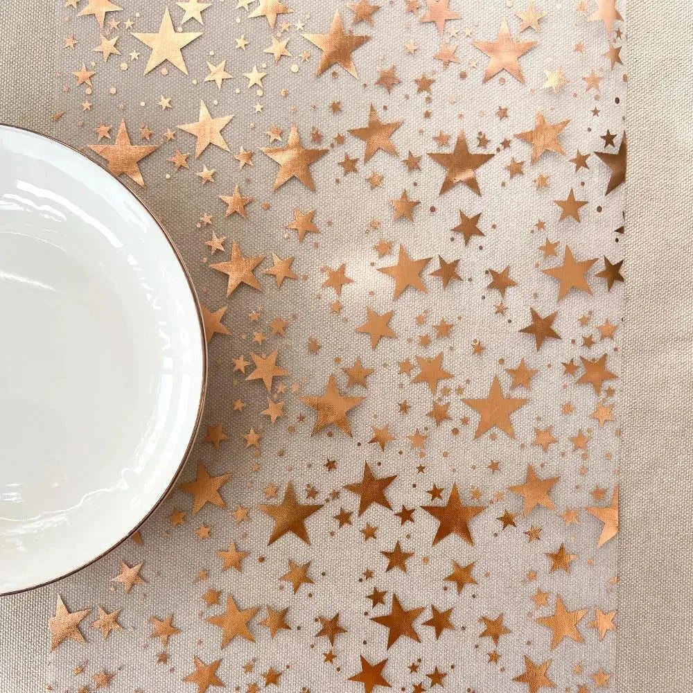 Chemin de table à étoiles rose gold avec assiette blanche