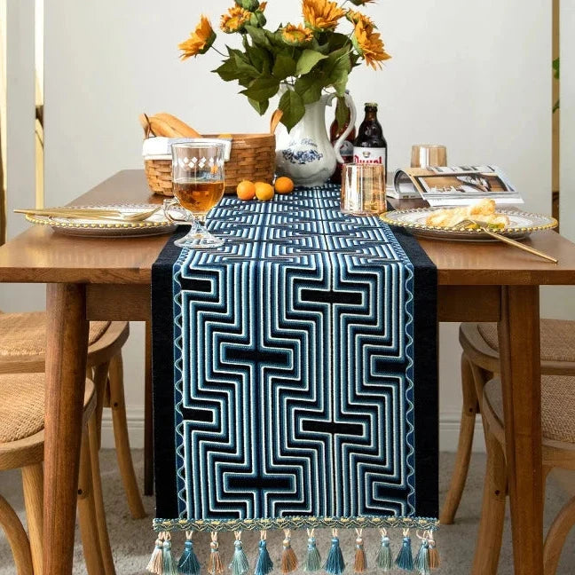 Chemin de table jacquard arabesque bleue à pompons dans une salle à manger