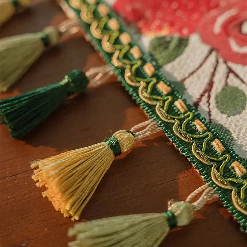 Détail des pompons verts et dorés du chemin de table jacquard camélias