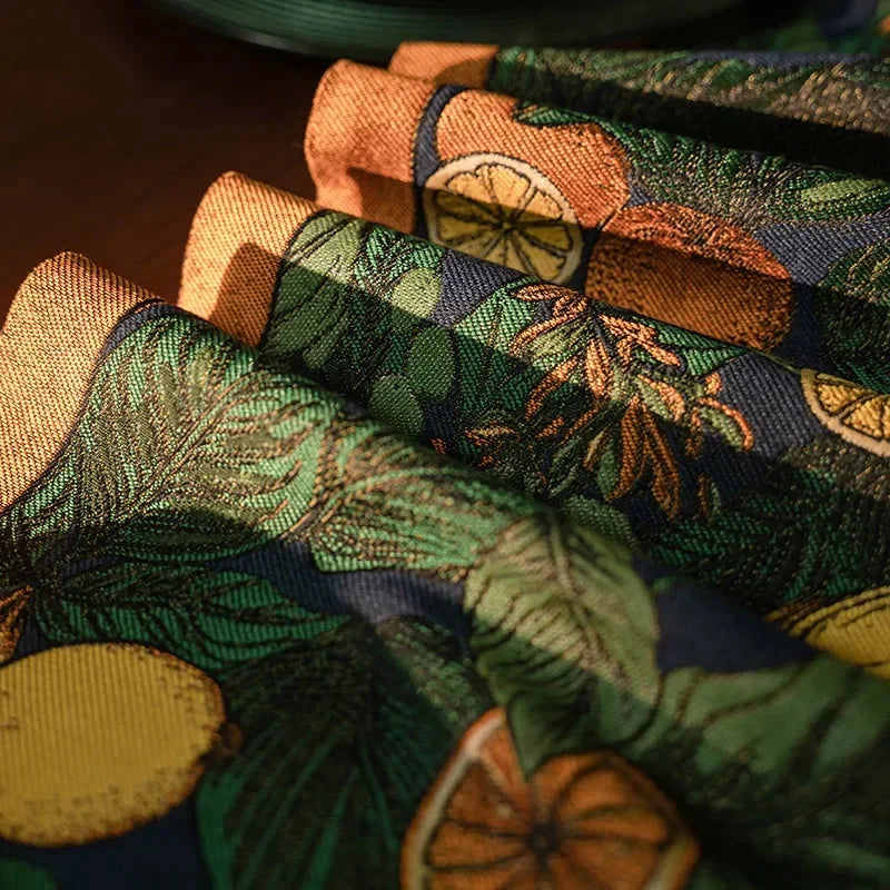 Chemin de table jacquard citrons verts — plis du tissu et lisière dorée