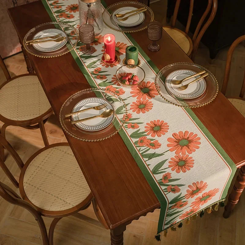 Chemin de table jacquard fleurs orange sur table dressée avec assiettes