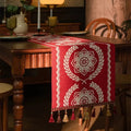 Chemin de table jacquard médaillons rouges sous une lampe d’ambiance