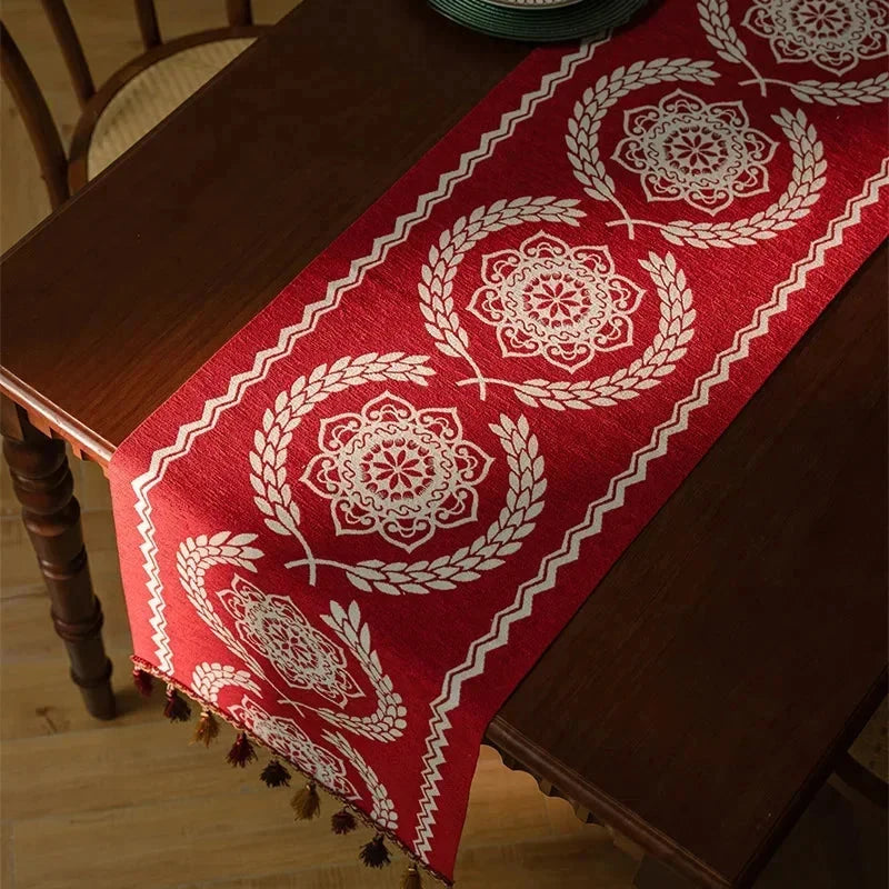 Chemin de table jacquard médaillons rouges sur un coin de table en bois