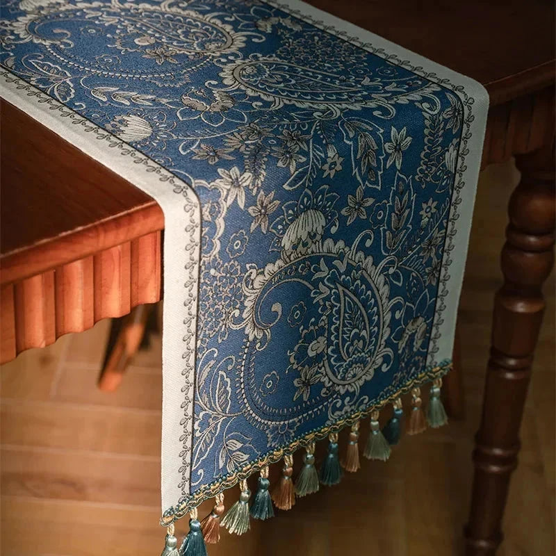 Chemin de table jacquard plumes bleues — angle de table et pompons