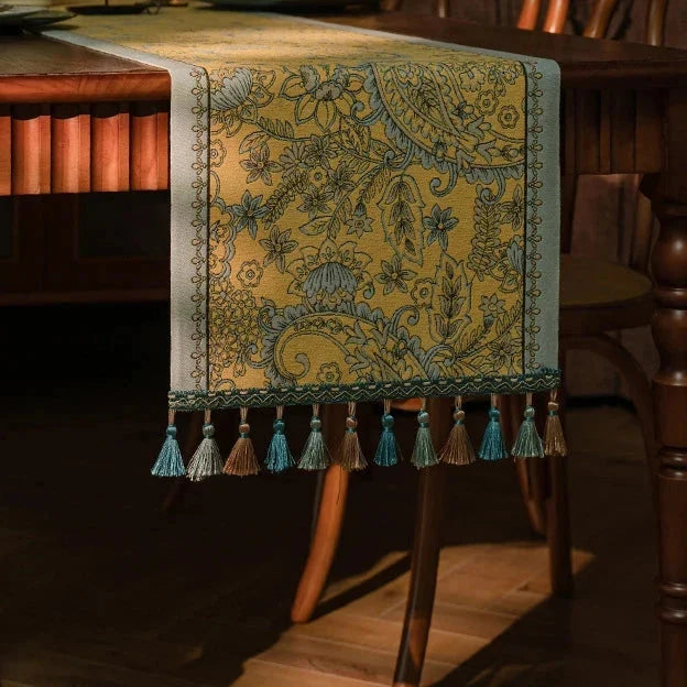 Chemin de table jacquard plumes dorées drapé sur une chaise en bois