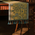 Chemin de table jacquard plumes dorées drapé sur une chaise en bois