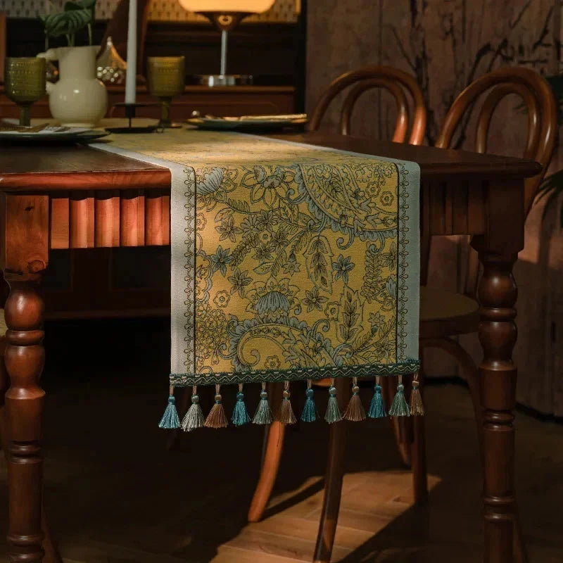 Chemin de table jacquard plumes dorées sous une lampe d’ambiance