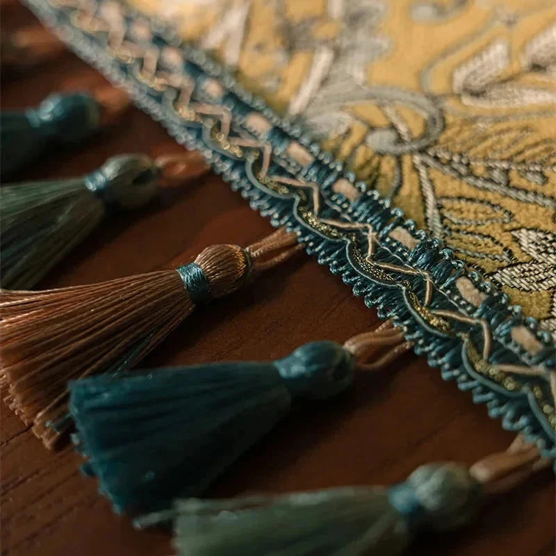 Détail de la lisière et des pompons du chemin de table plumes dorées
