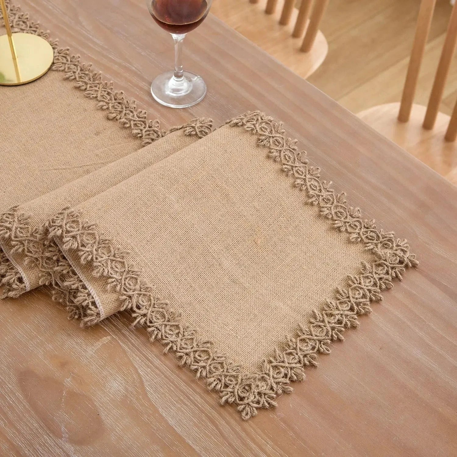 Chemin de table en jute naturel à bordure dentelle sur une table en bois