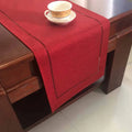 Chemin de table en lin uni bordeaux sur une table en bois