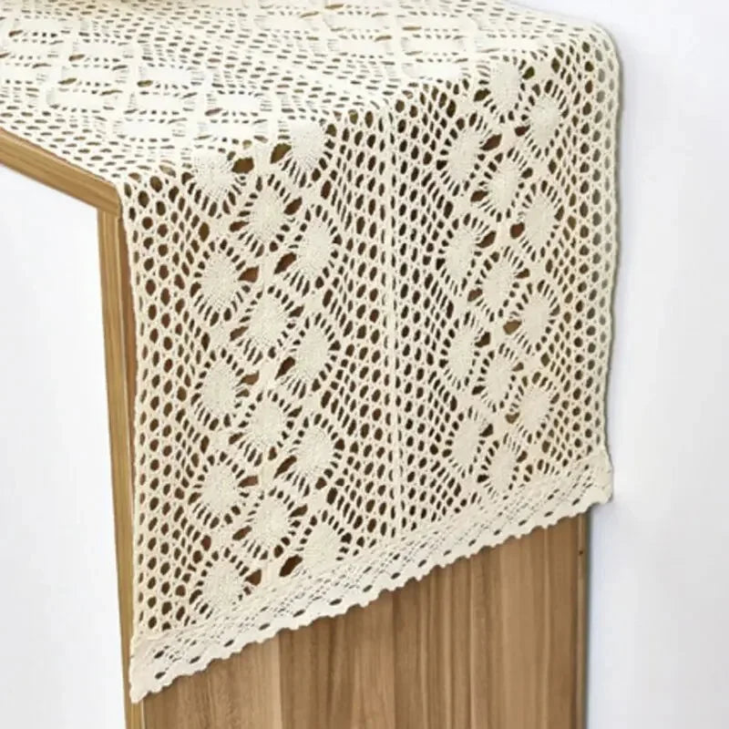 Chemin de table en crochet crème à losanges sur une console en bois