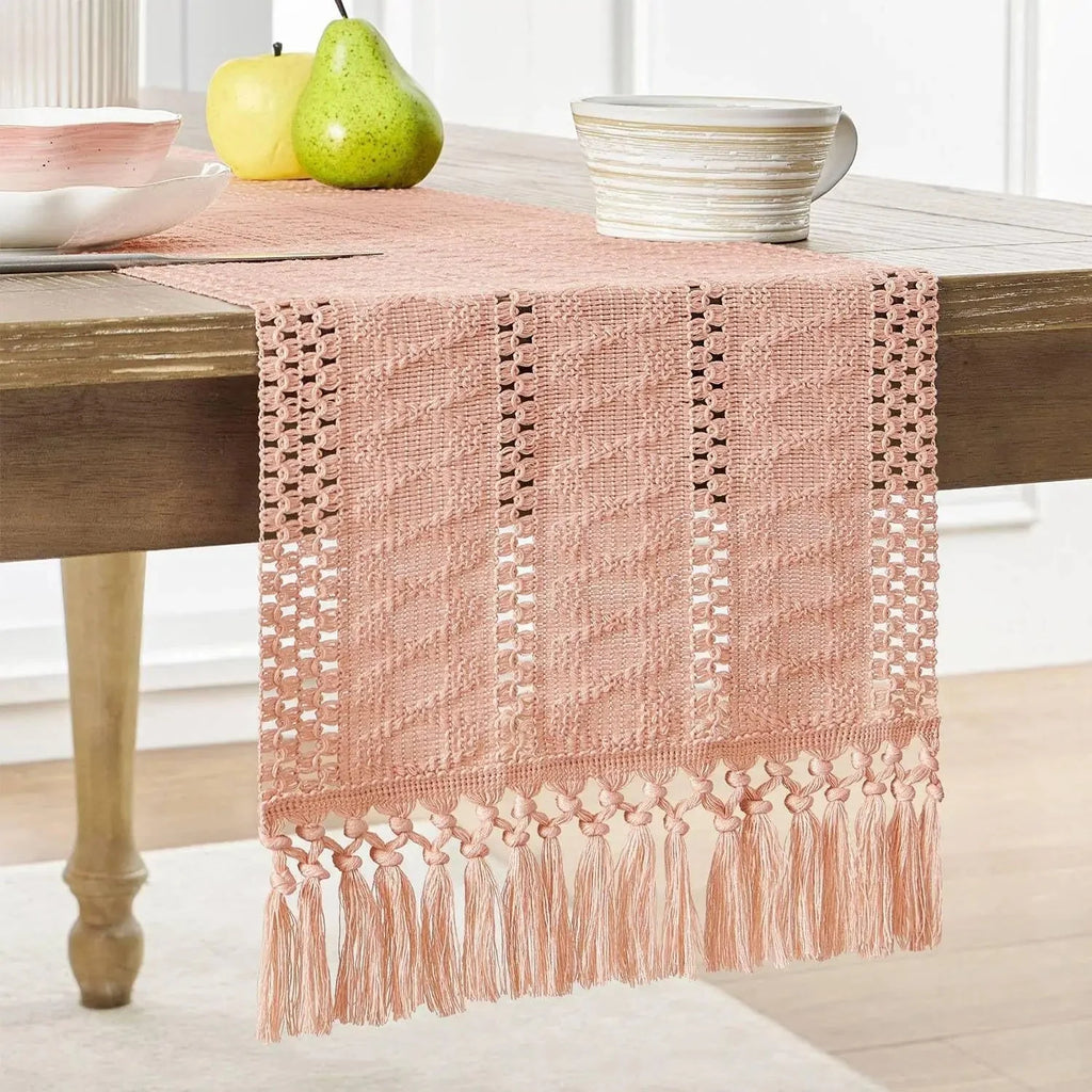 Chemin de table en macramé rose à franges sur une table en bois