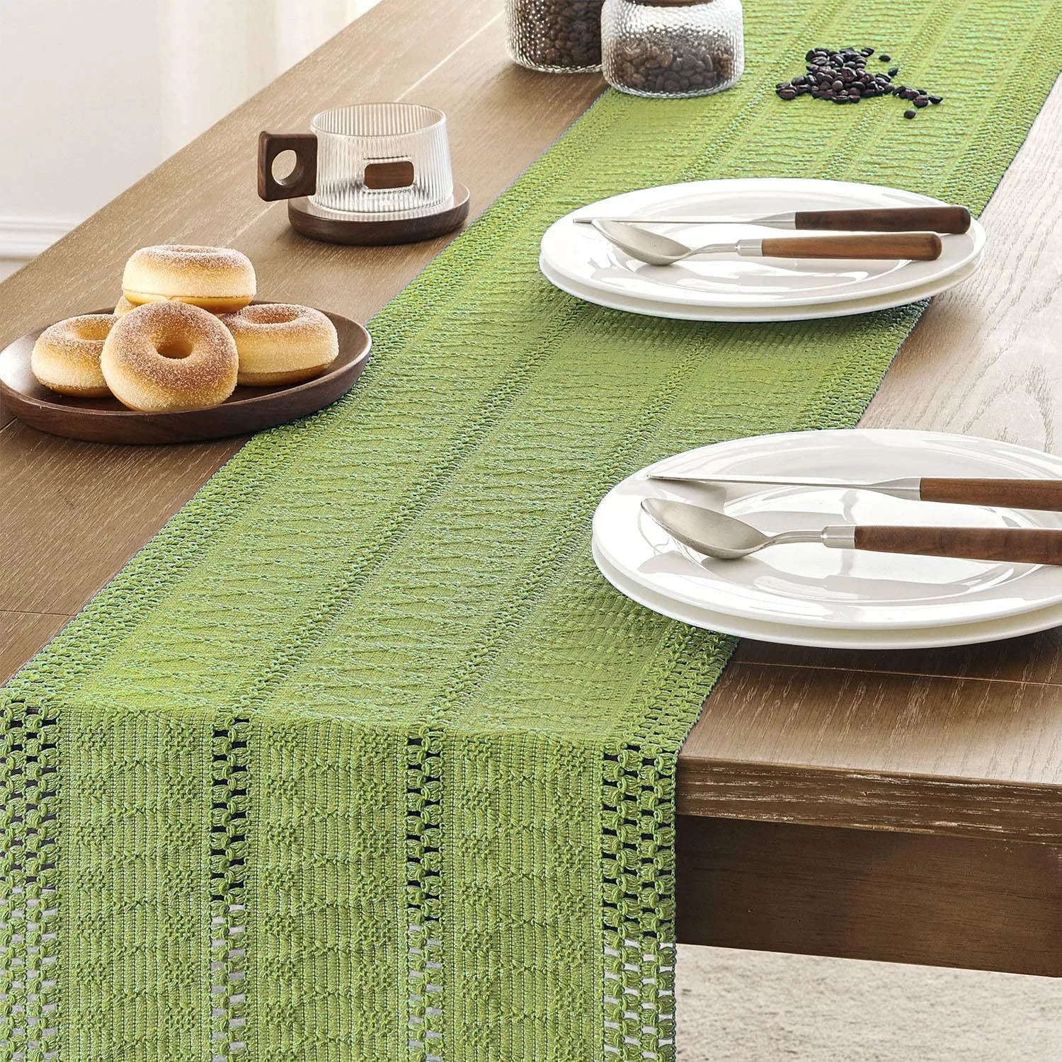 Chemin de table en macramé vert sauge sur une table dressée — assiettes et café