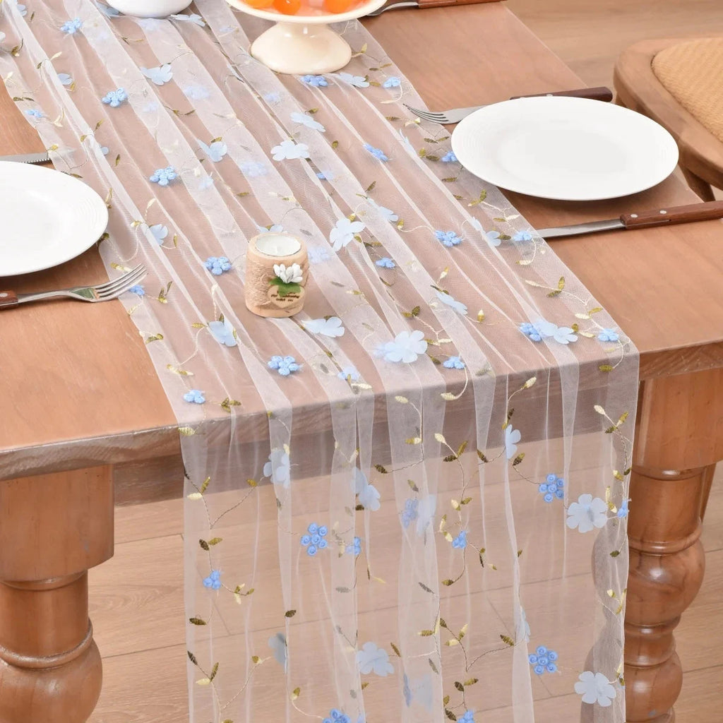 Chemin de table en tulle marguerites bleu ciel sur une table en bois
