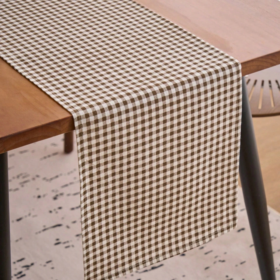 Chemin de table à carreaux vichy marron et blanc drapé sur une table en bois